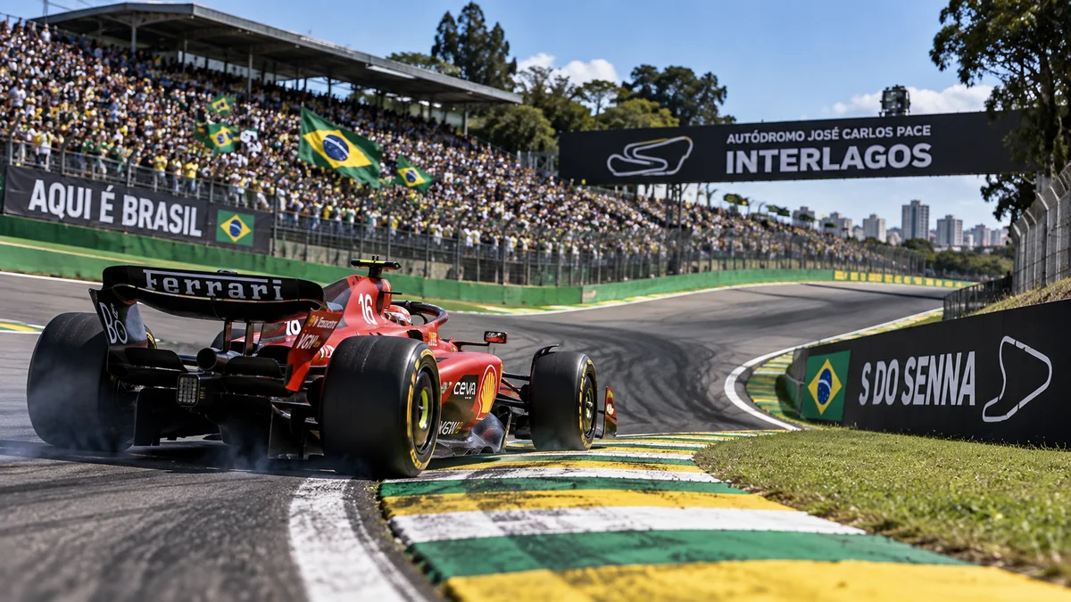 Carro de Fórmula 1 vermelho contorna a curva do S do Senna em Interlagos, com a torcida ao fundo