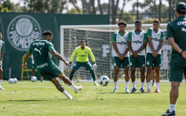 Jogador do Palmeiras cobra falta contra uma barreira de companheiros durante treino