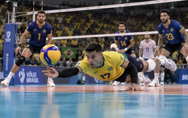 Líbero de camisa amarela mergulha para defender a bola na quadra